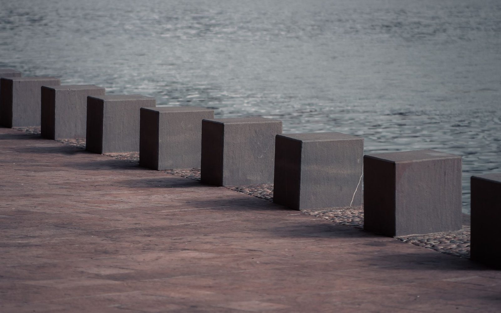 Large paved waterfront area with concrete bollards