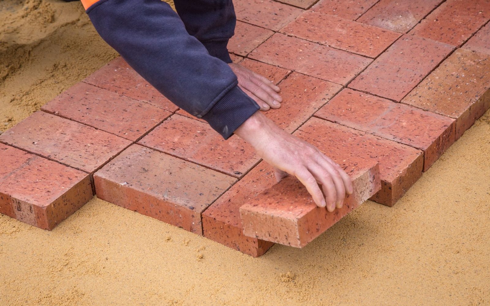 Paving blocks being laid by hand onto a screeded sand bed