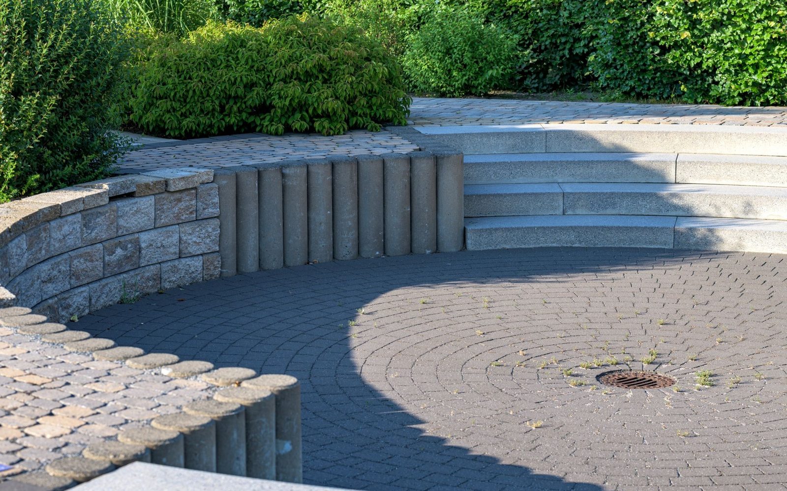 Circular paved patio area with stone steps and block edging